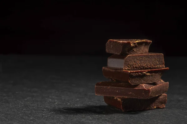 Μαύρη σοκολάτα σε μια πέτρα. Σκούρο φόντο. — Φωτογραφία Αρχείου