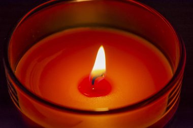 Cam bardakta mum. Sıcak ışık.