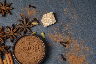 Esmer yıldızlı anason ve tarçın. Bir fincanda tarçın. Kakule ve kamış şekeri.