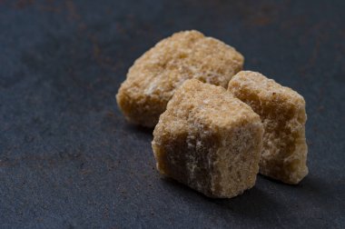 Koyu taştan bir zemin üzerinde kamış esmer şeker