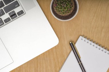 Laptoplu ahşap masa masası, bir fincan kahve ve malzeme. Kopyalama alanı olan üst görünüm, düz yatay.