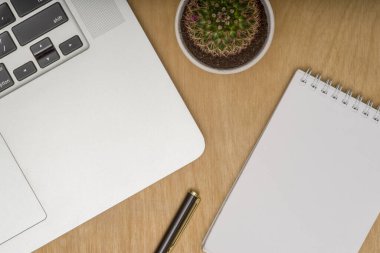 Laptoplu ahşap masa masası, bir fincan kahve ve malzeme. Kopyalama alanı olan üst görünüm, düz yatay.