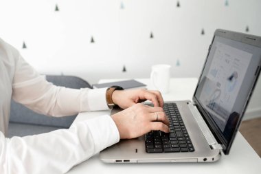 İş adamıyım. Kanepede otururken dizüstü bilgisayarda çalışan adamın görüntüsü