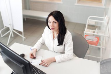 Laptop bilgisayarında çalışan kadın doktorlar, hastane veya klinikteki kayıt bilgileriyle reçeteli not defterleri, sağlık hizmetleri ve tıbbi konsept