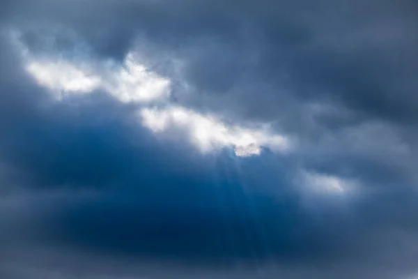 Dramatic sky with sunbeams through the clouds