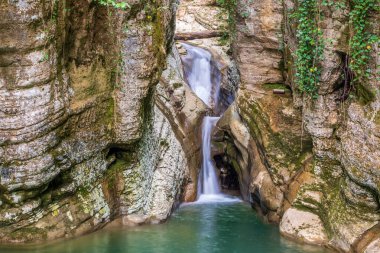 Dağ nehri ve şelale. Taştan bir vadide berrak turkuaz suyu..