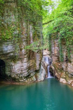 Dağ nehri ve şelale. Taştan bir vadide berrak turkuaz suyu..