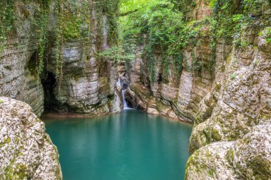 Dağ nehri ve şelale. Taştan bir vadide berrak turkuaz suyu..