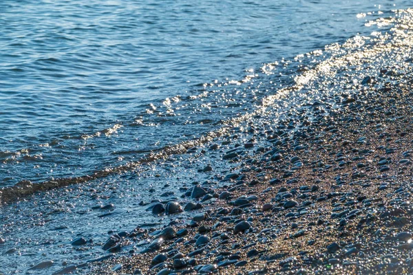 Морская волна с пеной на галечном пляже . — стоковое фото