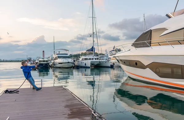 Junge vertäut eine große Jacht auf einem Dock. — Stockfoto