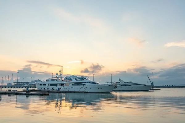 Vacker orange solnedgång i havet hamnen med förtöjda båtar. Dyr 92 fot yacht vid piren under solnedgången — Stockfoto