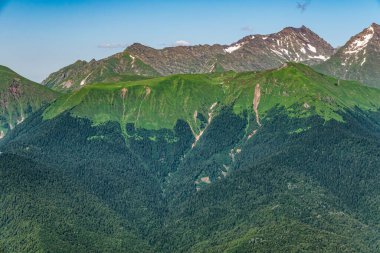 Yeşil yamaçlarda ve karlı doruklara sahip yüksek dağlar. Yaz aylarında dağ aralıkları.