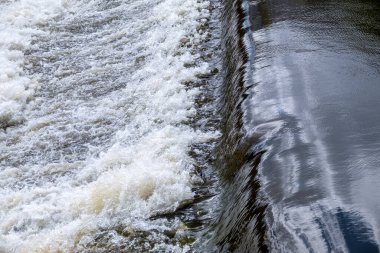 Sakin bir nehirde küçük düz bir şelale. Su arkaplanı