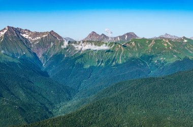 Yeşil yamaçlarda ve karlı doruklara sahip yüksek dağlar. Yaz aylarında dağ aralıkları.