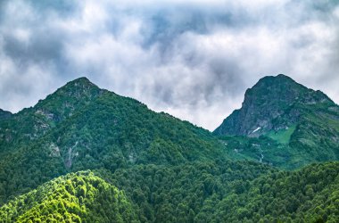 Yaz bulutlu bir günde yeşil dağ yamacı. Kalın bulutlu dağ manzarası.
