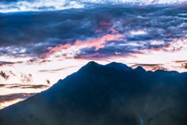 Pembe günbatımında dağ silueti. Dağlarda güzel pembe gün batımı