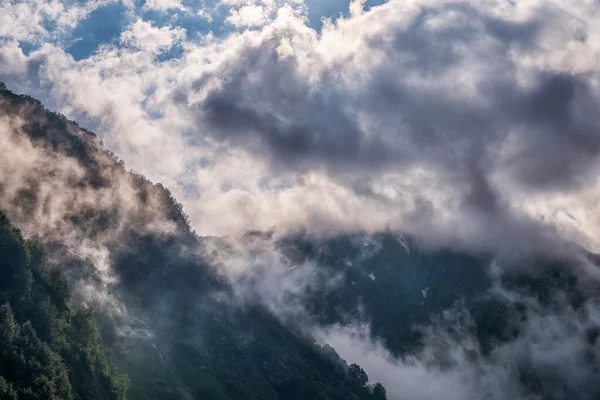 Yeşil Yamaçlı Yüksek Dağlar Yoğun Bulutlar Sis Içinde Erimemiş Kar — Stok fotoğraf