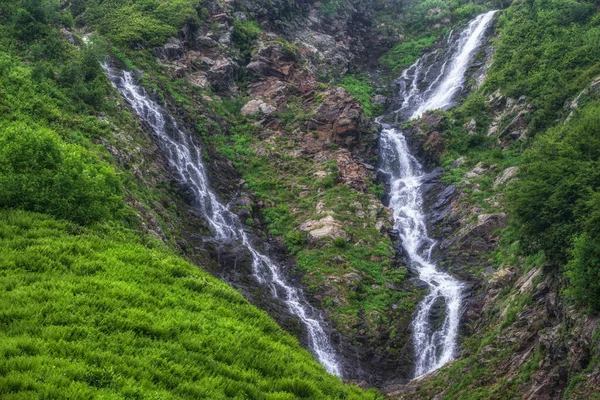 Green mountain range with waterfall and in spring or summer. Powerful stream of mountain river with waterfall. Achipsa waterfalls, Krasnaya Polyana, Sochi, Russia