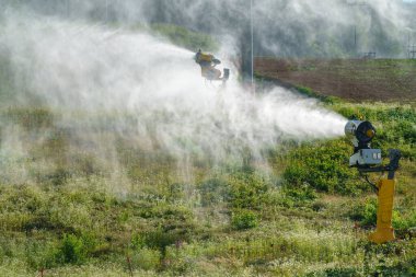 Yazın dağ kayak merkezinde kar silahı. Bir yamaç kar makinesi yaz mevsiminde önleme için çalışır. Kar makinesi yazın çalışır..