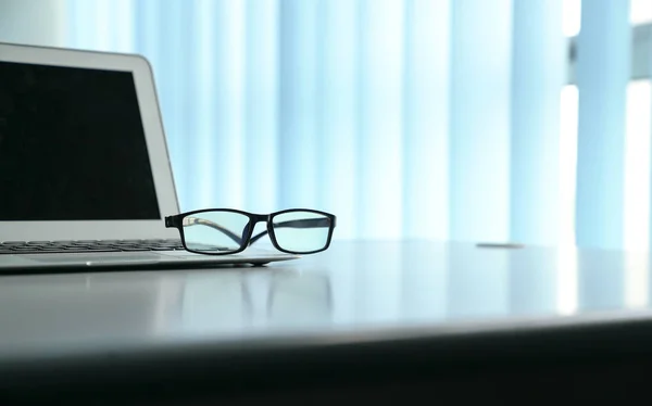 Офисный стол с ноутбуком и очками для чтения. Спак для копирования — стоковое фото