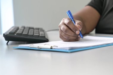 Kalemle kağıda yazan bir kadın.