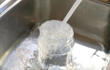 Musluktan plastik konteynıra su ve lavaboya taşar..