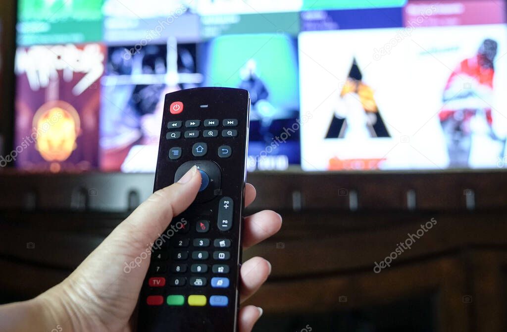 Female hand holding a smart tv remote control