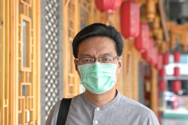 Portrait of Asian Chinese man wearing surgical face mask.