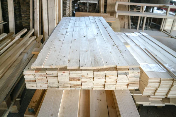 Pile of pine wood in a warehouse or storage room. Wood proceesing, wood for furniture