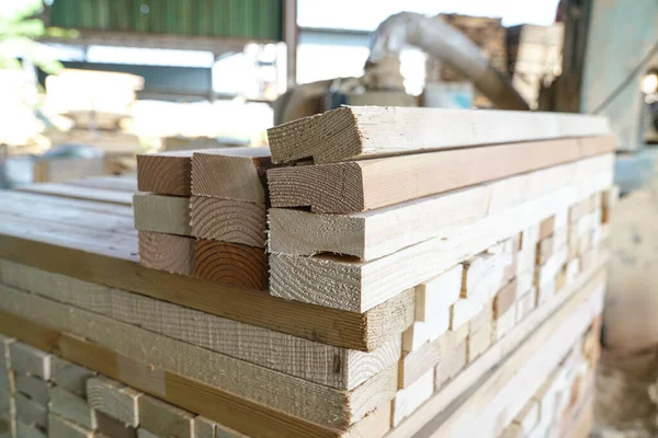 Pile of pine wood in a warehouse or storage room. Wood proceesing, wood for furniture