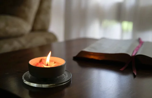 在桌子上点着蜡烛 后面放着书 窗帘和沙发 — 图库照片