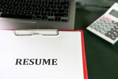 Masadaki dizüstü bilgisayarın üstüne özgeçmişin kapatılması