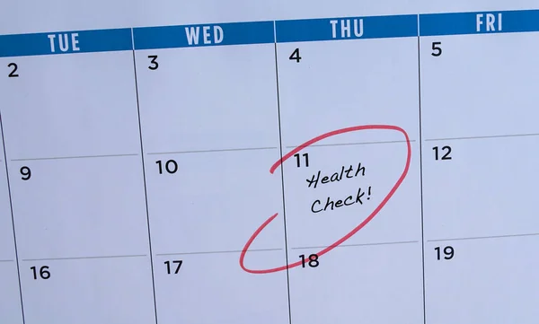 Health check, words in calendar. Circled in red. Medical screening or reminder concept.