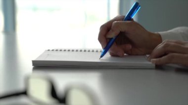 İş kadını not defterine bir şeyler yazıyor ya da karalıyor. Ofis ayarlama. - Yakın çekim. Yavaş çekim.