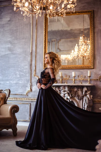Belle jeune femme en magnifique robe de soirée noire avec un maquillage et une coiffure parfaits — Photo