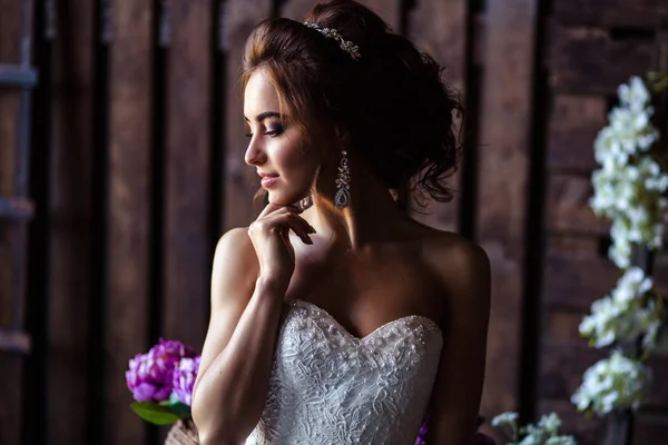 Hinreißende Braut junge Frau in einem Hochzeitskleid mit perfektem Make-up und Frisur — Stockfoto