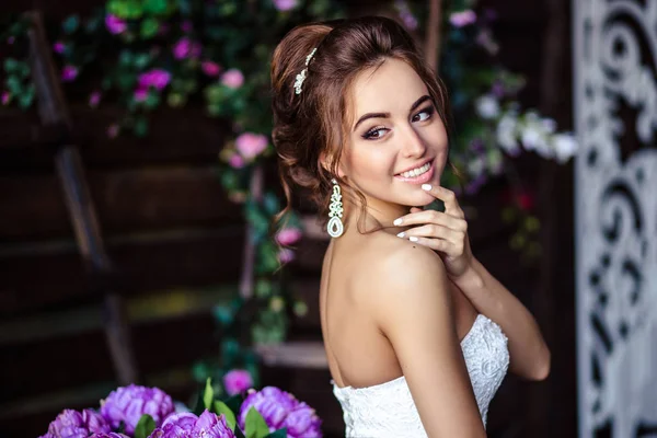 Linda noiva jovem mulher em um vestido de noiva com maquiagem perfeita e penteado — Fotografia de Stock