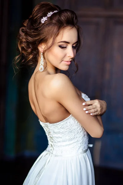 Hinreißende Braut junge Frau in einem Hochzeitskleid mit perfektem Make-up und Frisur — Stockfoto