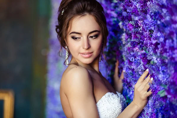 Linda noiva jovem mulher em um vestido de noiva com maquiagem perfeita e penteado — Fotografia de Stock
