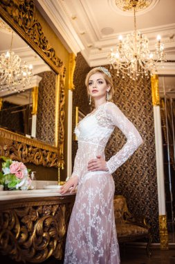 Beyaz bir banyo iç çamaşırlarıyla güzel sarışın genç kadın. Gelinin sabah