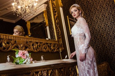 Beyaz bir banyo iç çamaşırlarıyla güzel sarışın genç kadın. Gelinin sabah