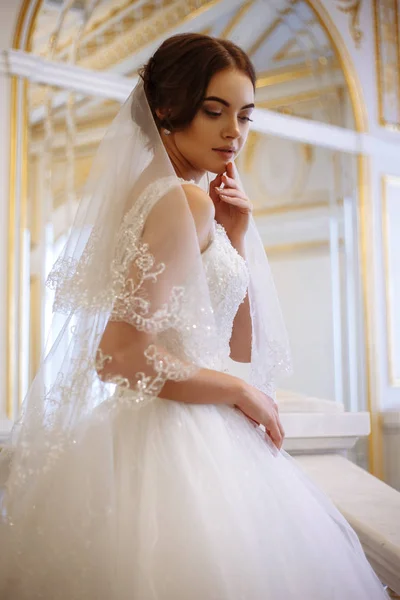 Bella giovane donna sposa in abito da sposa di lusso in interni — Foto Stock