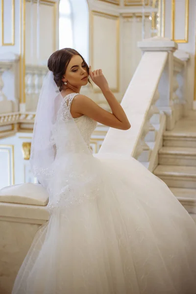 Bella giovane donna sposa in abito da sposa di lusso in interni — Foto Stock