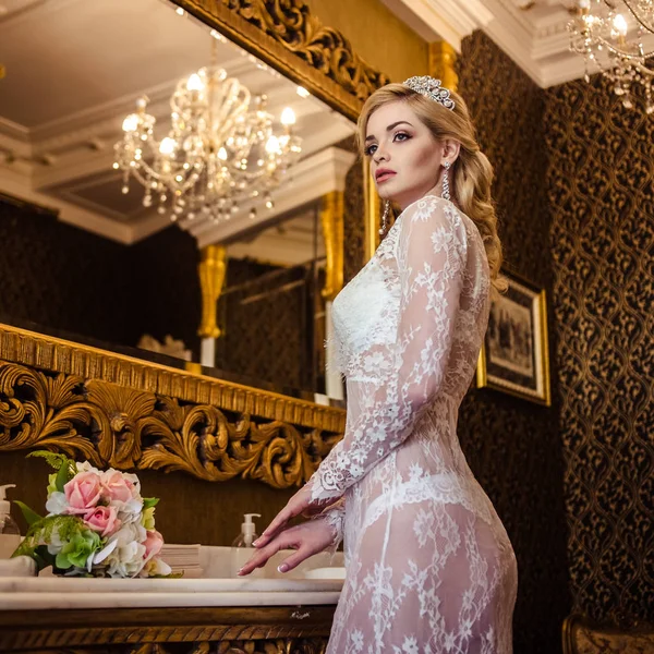 Belle jeune femme blonde en lingerie blanche dans une salle de bain intérieure. le matin de la mariée — Photo