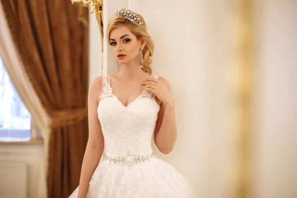 Schöne junge Frau Braut in Luxus-Hochzeitskleid im Inneren — Stockfoto