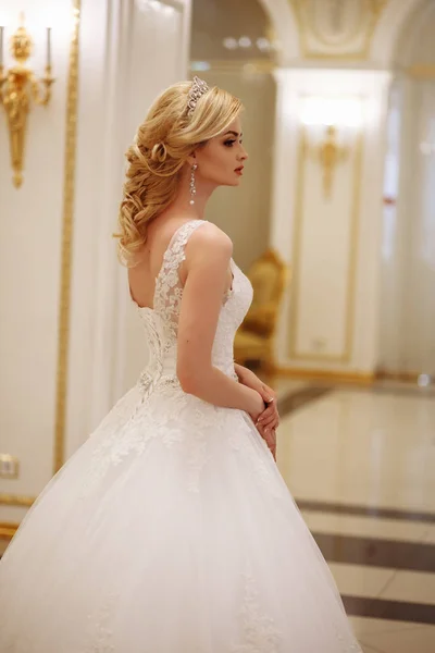 Mooie jonge vrouw bruid in luxe trouwjurk in interieur — Stockfoto