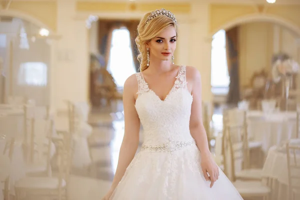 Mooie jonge vrouw bruid in luxe trouwjurk in interieur — Stockfoto