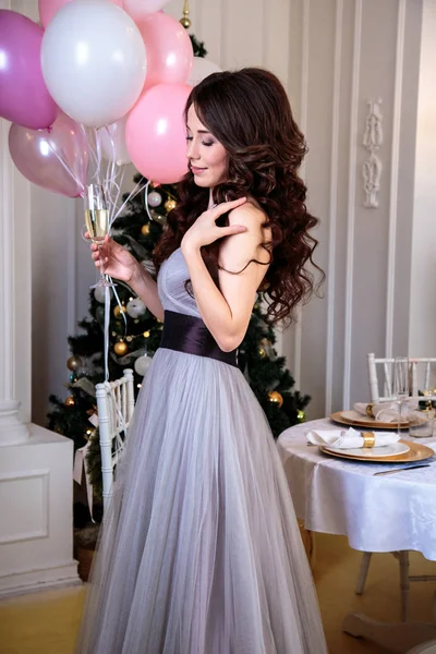 Hermosa mujer joven en vestido de noche de lujo con globos de aire sobre fondo de Navidad —  Fotos de Stock