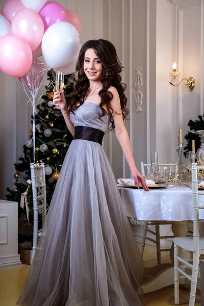 クリスマス背景に気球がある高級イブニング ドレスで美しい若い女性 — ストック写真