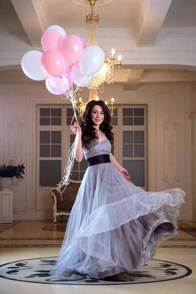 Belle jeune femme en robe de soirée de luxe avec des ballons à air à l'intérieur — Photo